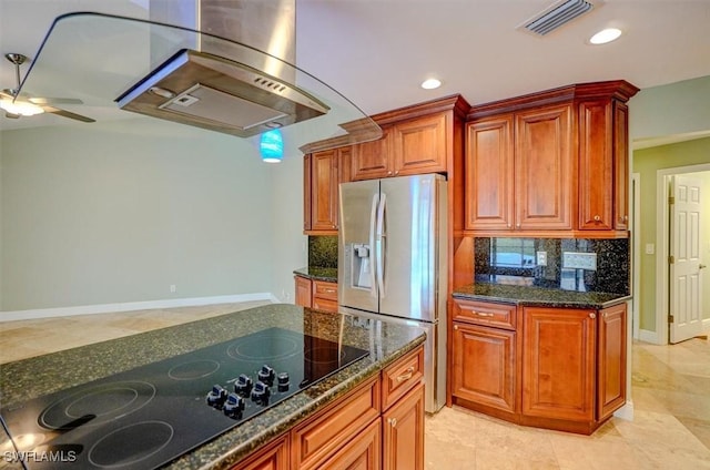 kitchen featuring ceiling fan, backsplash, dark stone countertops, stainless steel fridge with ice dispenser, and black electric cooktop