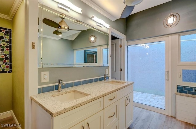 bathroom featuring lofted ceiling, ceiling fan, vanity, wood-type flooring, and ornamental molding