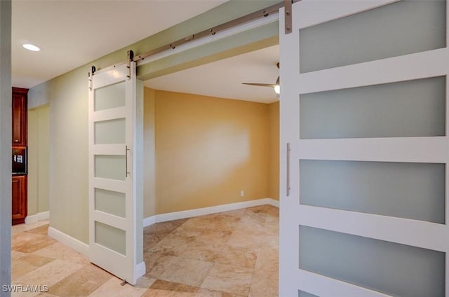 interior space with ceiling fan, built in features, and a barn door