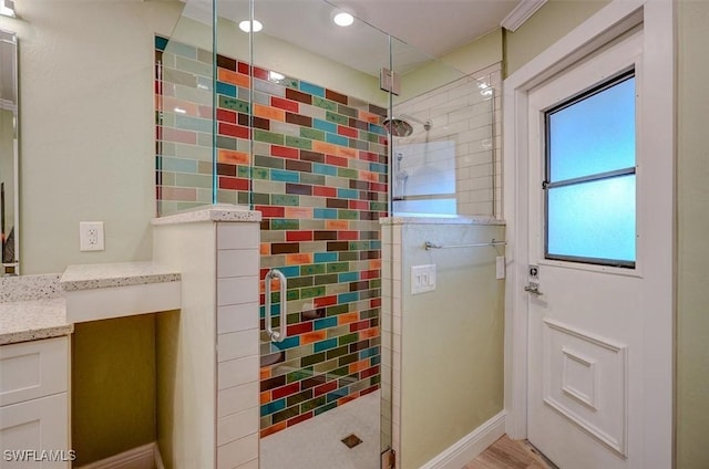 bathroom with hardwood / wood-style floors, walk in shower, and vanity