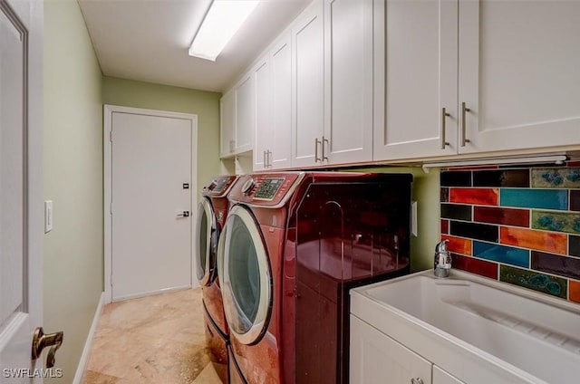 clothes washing area with cabinets and independent washer and dryer