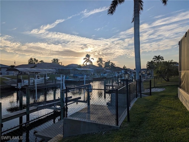 dock area featuring a water view and a lawn