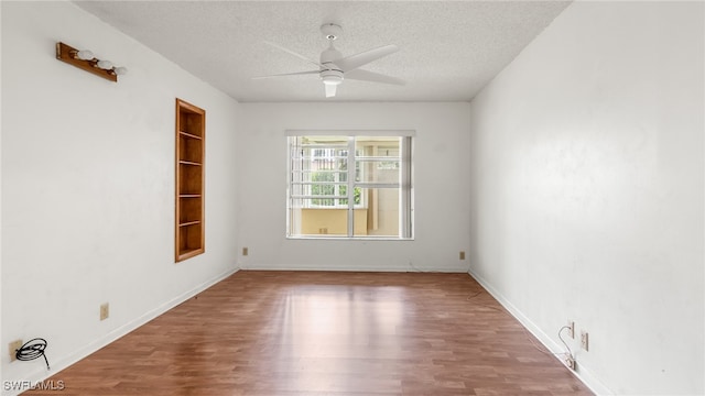 unfurnished room featuring ceiling fan, hardwood / wood-style floors, and a textured ceiling