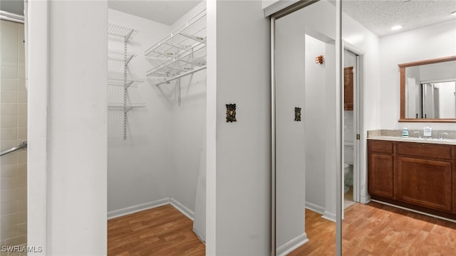 bathroom with wood-type flooring, vanity, a textured ceiling, and toilet