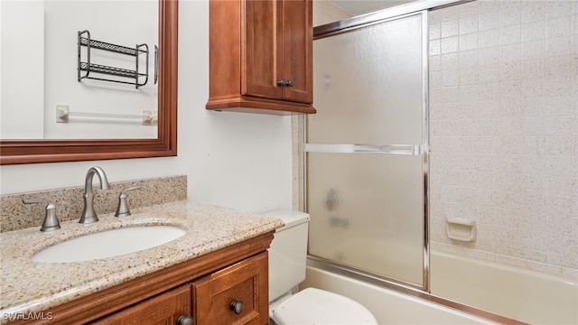 full bathroom with vanity, toilet, and enclosed tub / shower combo