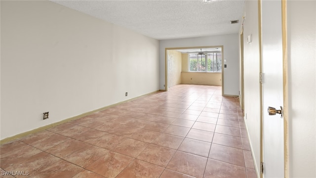 empty room with light tile patterned floors and a textured ceiling