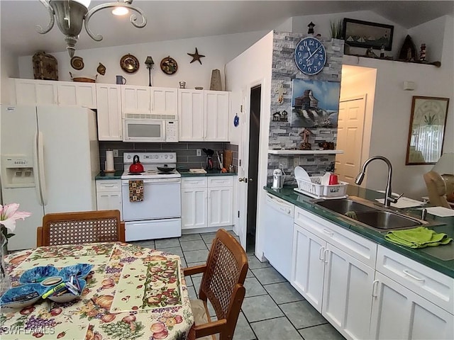 kitchen with white appliances, backsplash, sink, light tile patterned flooring, and white cabinetry