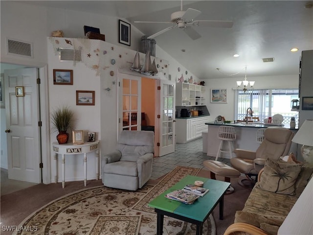 living room with ceiling fan with notable chandelier, high vaulted ceiling, and sink