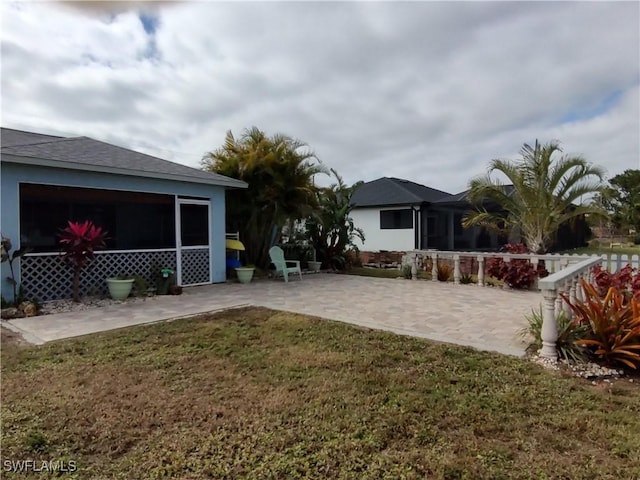 view of yard with a sunroom and a patio area