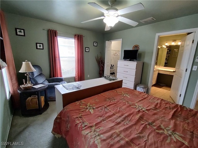 carpeted bedroom featuring ensuite bath and ceiling fan