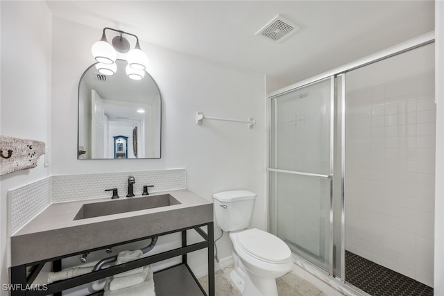 bathroom with tile patterned floors, toilet, a shower with shower door, and sink