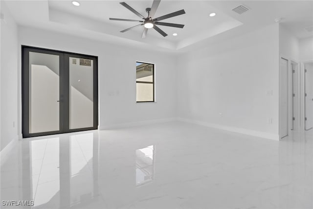 spare room with french doors, a raised ceiling, and ceiling fan