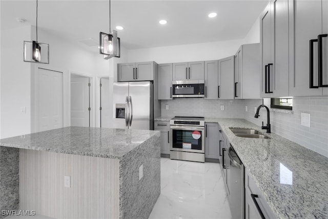 kitchen with a center island, light stone counters, sink, and appliances with stainless steel finishes