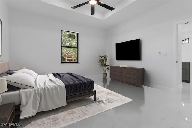 bedroom featuring ceiling fan and a raised ceiling