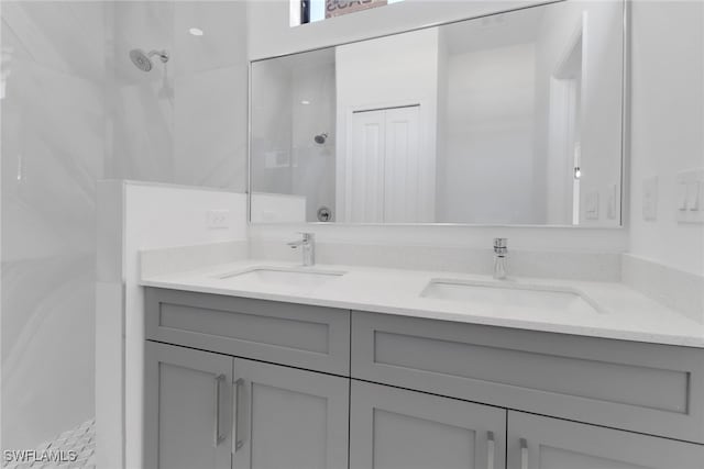 bathroom featuring a tile shower and vanity