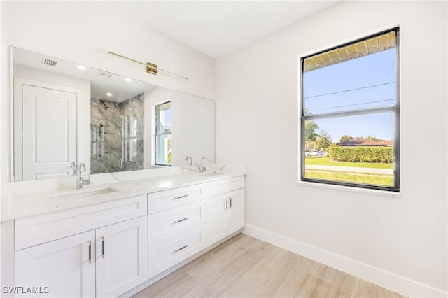 bathroom with walk in shower, hardwood / wood-style floors, vanity, and a wealth of natural light