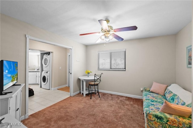 interior space with light carpet, sink, stacked washer / dryer, and ceiling fan