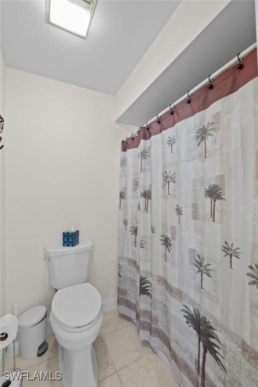 bathroom with tile patterned floors, a shower with shower curtain, and toilet