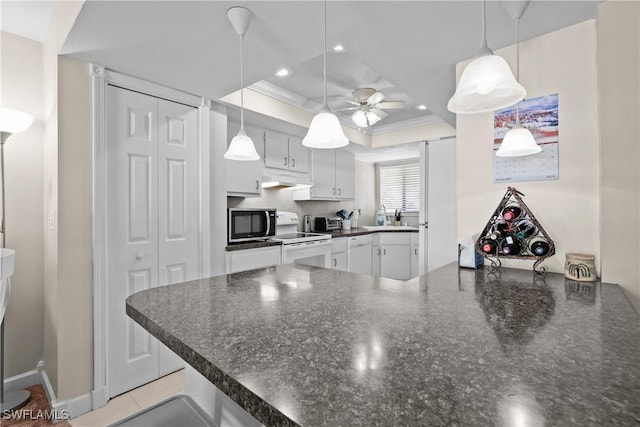 kitchen featuring kitchen peninsula, decorative light fixtures, a tray ceiling, and white cabinetry