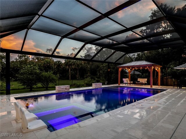 view of pool featuring an in ground hot tub, a patio, glass enclosure, and a gazebo