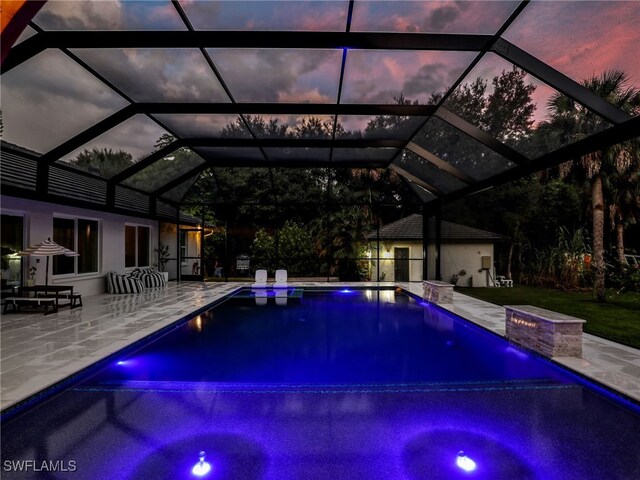 pool at dusk featuring an outdoor pool and a patio