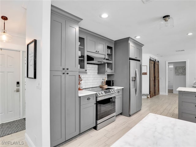 kitchen with stainless steel appliances, backsplash, gray cabinets, and under cabinet range hood