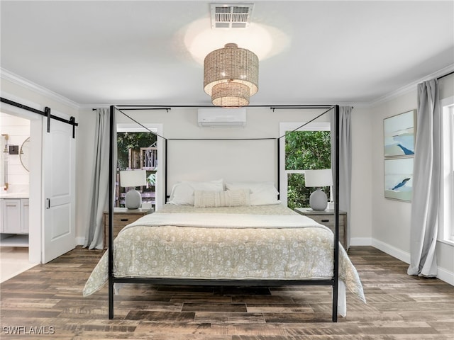 bedroom featuring a barn door, multiple windows, a wall unit AC, and visible vents