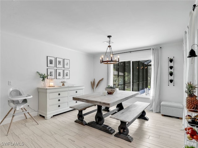 dining area with a notable chandelier, crown molding, baseboards, and light wood-style floors