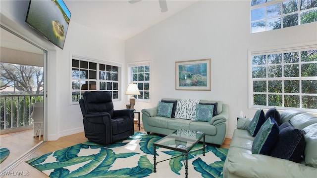 living room with hardwood / wood-style flooring, a healthy amount of sunlight, and vaulted ceiling