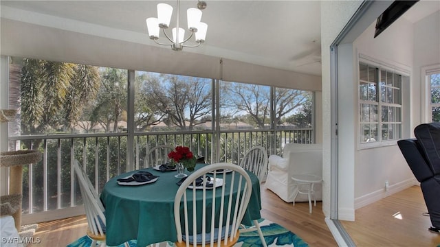 sunroom featuring a chandelier and plenty of natural light