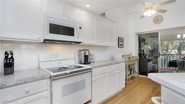 kitchen featuring white appliances, white cabinets, light hardwood / wood-style flooring, ceiling fan, and tasteful backsplash