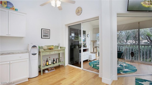 interior space featuring light wood-type flooring, white cabinetry, and ceiling fan