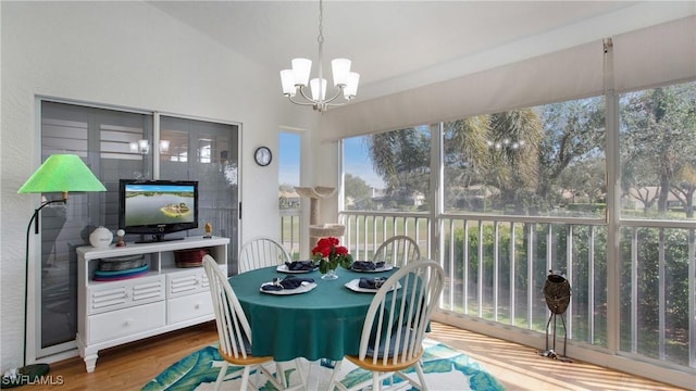 sunroom / solarium featuring vaulted ceiling, a healthy amount of sunlight, and a notable chandelier