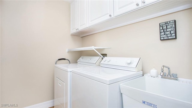 laundry room featuring cabinets, sink, and washing machine and clothes dryer