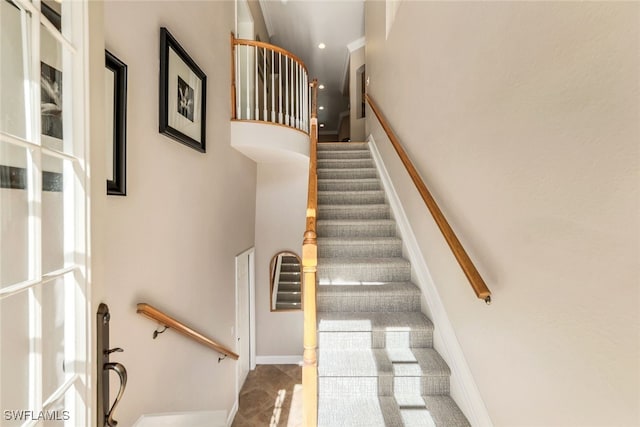 stairway featuring a towering ceiling