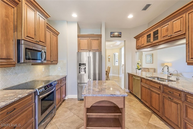 kitchen with light stone countertops, sink, decorative backsplash, light tile patterned flooring, and appliances with stainless steel finishes