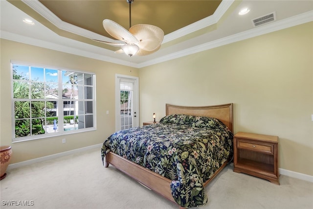 carpeted bedroom featuring a raised ceiling, ceiling fan, and ornamental molding