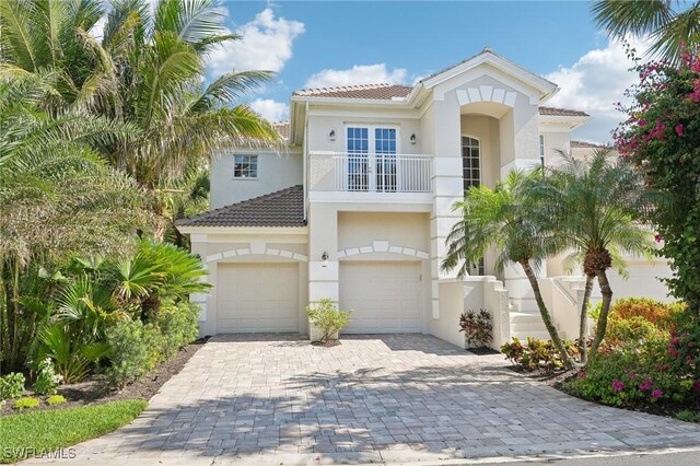 25970 Nesting Ct Unit 201, Bonita Springs, FL 34134 - mediterranean / spanish-style house featuring an attached garage, a balcony, decorative driveway, and a tile roof