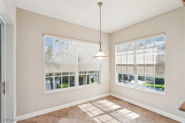 25970 Nesting Ct Unit 201, Bonita Springs, FL 34134 - unfurnished dining area featuring healthy amount of natural light, tile patterned floors, and baseboards