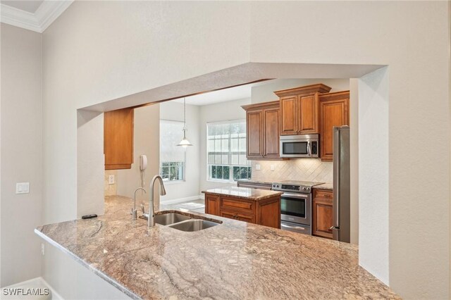 25970 Nesting Ct Unit 201, Bonita Springs, FL 34134 - kitchen with appliances with stainless steel finishes, a sink, brown cabinets, light stone countertops, and backsplash