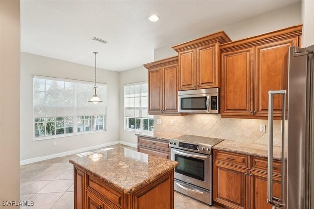25970 Nesting Ct Unit 201, Bonita Springs, FL 34134 - kitchen featuring stainless steel appliances, brown cabinets, tasteful backsplash, and recessed lighting