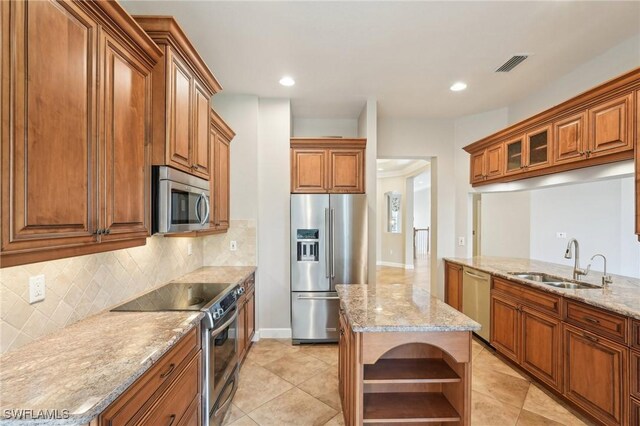 25970 Nesting Ct Unit 201, Bonita Springs, FL 34134 - kitchen featuring appliances with stainless steel finishes, a sink, open shelves, decorative backsplash, and light stone countertops