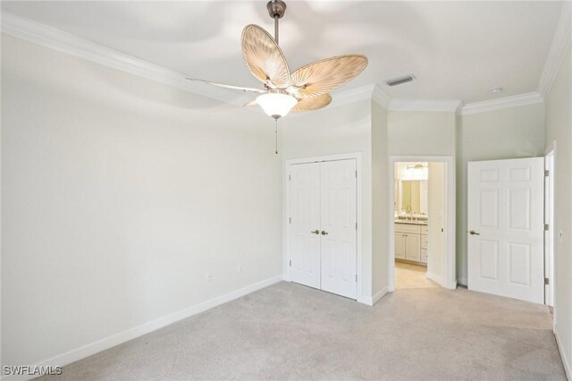 25970 Nesting Ct Unit 201, Bonita Springs, FL 34134 - unfurnished bedroom featuring crown molding, light colored carpet, a closet, baseboards, and a ceiling fan