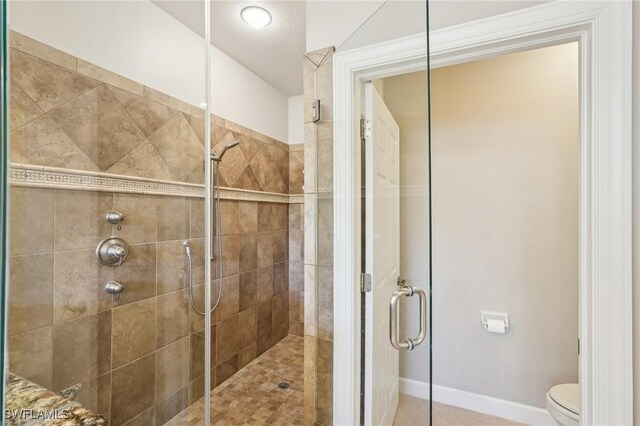25970 Nesting Ct Unit 201, Bonita Springs, FL 34134 - full bath featuring a stall shower, toilet, baseboards, and tile patterned flooring