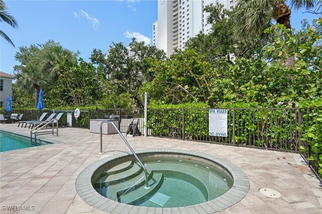 25970 Nesting Ct Unit 201, Bonita Springs, FL 34134 - community pool featuring a community hot tub and a patio area