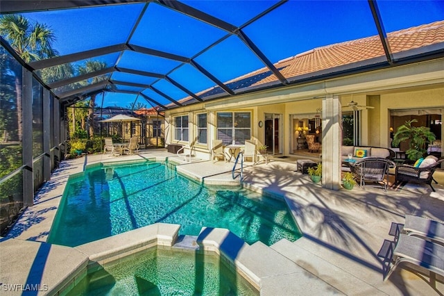 view of swimming pool featuring a patio, an outdoor hangout area, glass enclosure, and ceiling fan