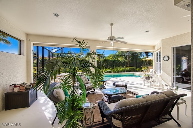 view of patio / terrace with ceiling fan, an outdoor living space, and glass enclosure