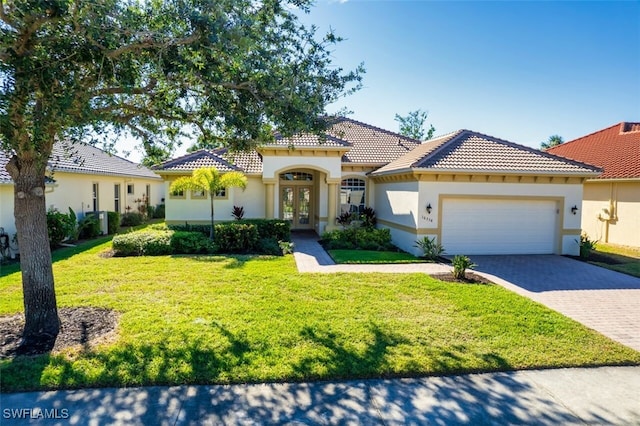 mediterranean / spanish-style house featuring french doors, a front yard, and a garage