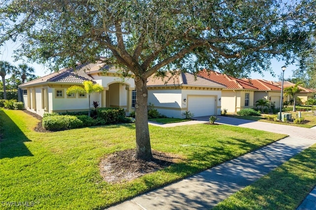 mediterranean / spanish-style home with a front yard and a garage