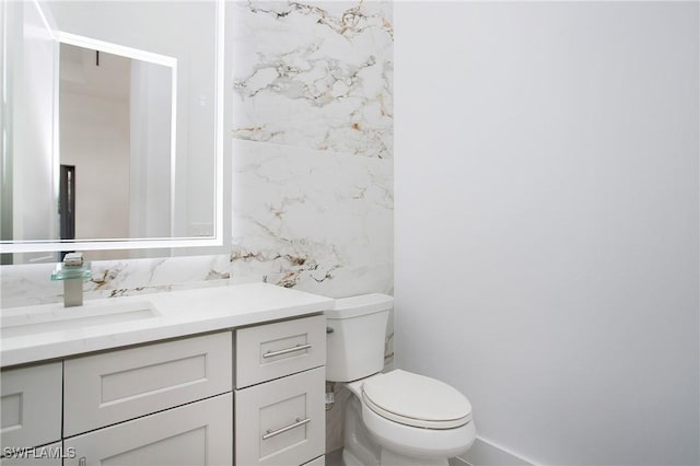 bathroom featuring vanity, toilet, and tile walls